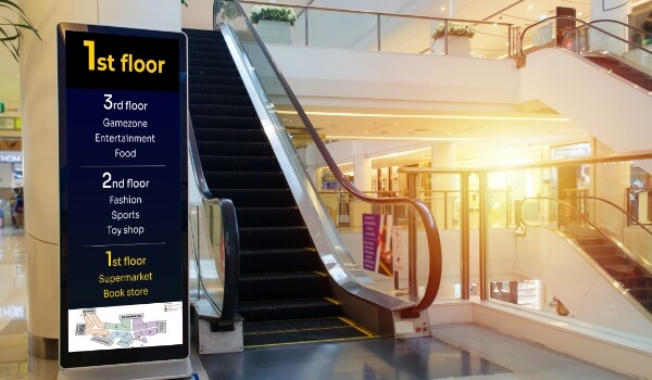 a digital lobby directory placed next to mall escalators