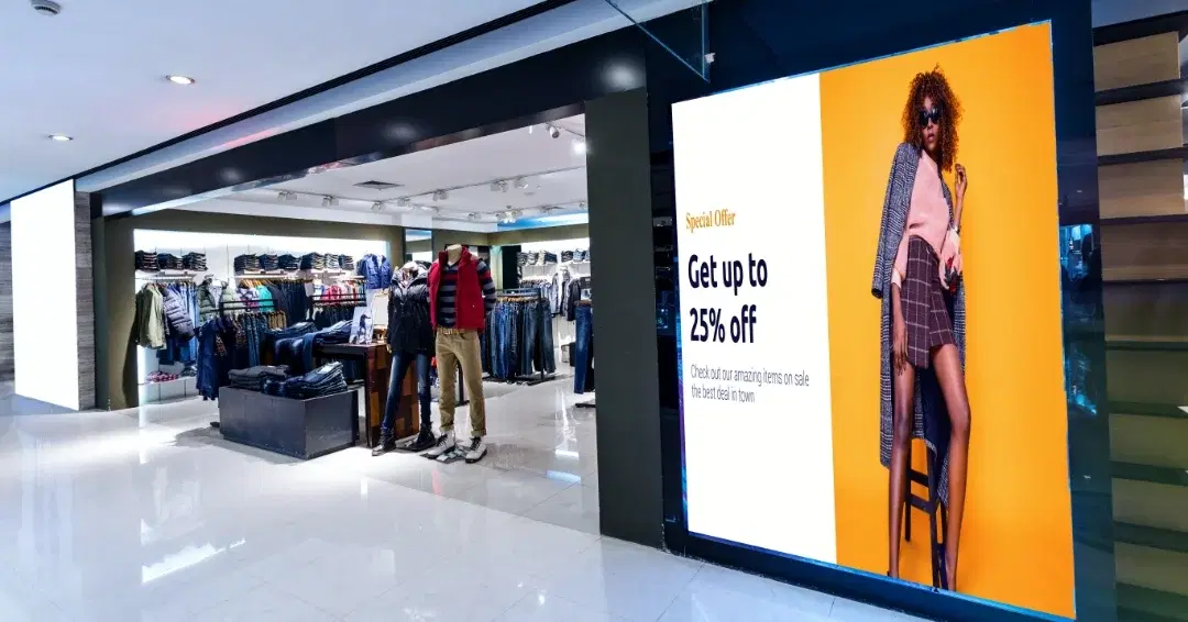 Digital Signage at the entrance of a retail clothing store displaying content about ongoing promotions