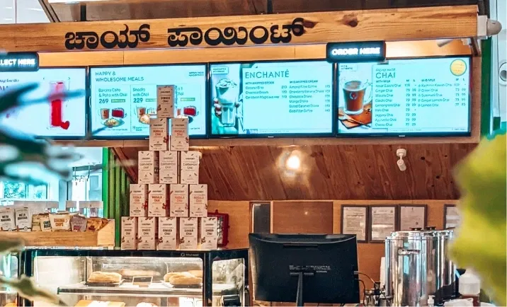 Digital signage placed at chai point store displaying digital menu board feed from can show local news app oneindia feeds