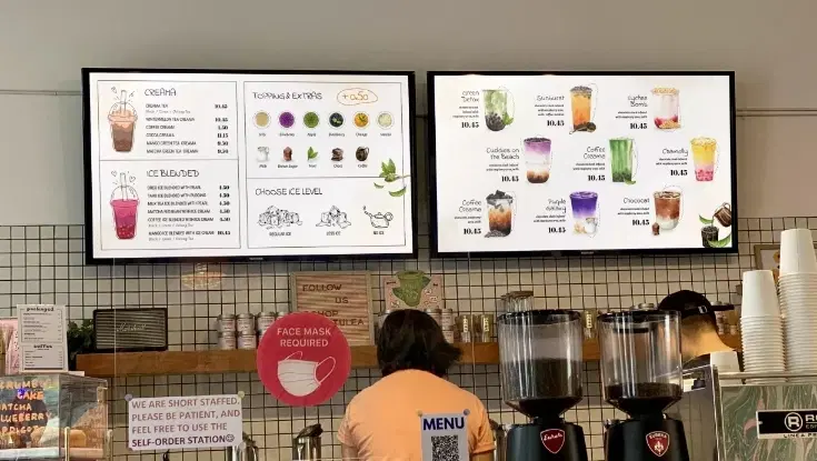 A cafe with digital menu boards showing the menu A cafe with digital menu boards showing the menu