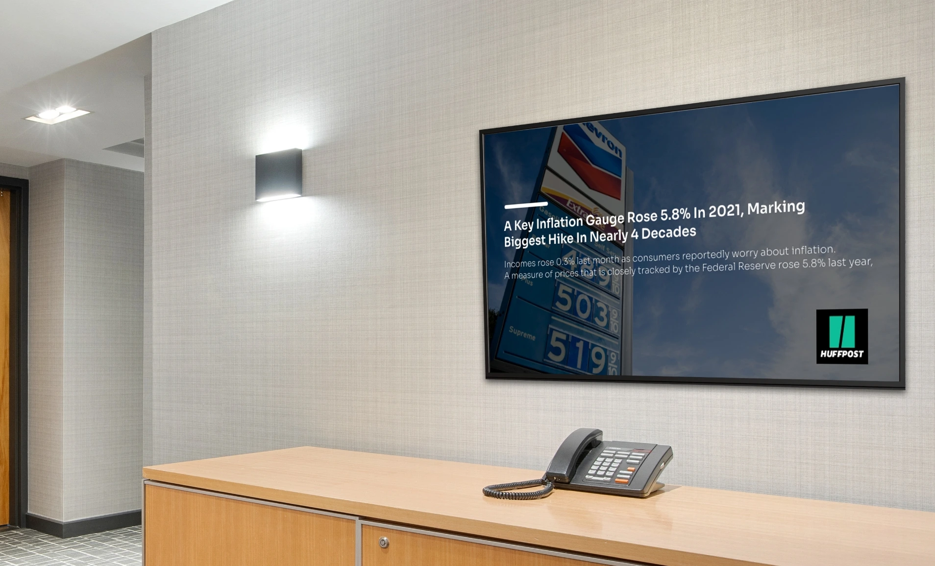 Digital signage screen on office reception wall showing Huffpost news feeds from Pickcel digital sigange software