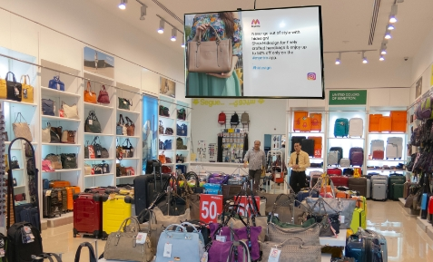 digital signage screen placed at retail store showing post from brand's Instagram page using Pickcel software.