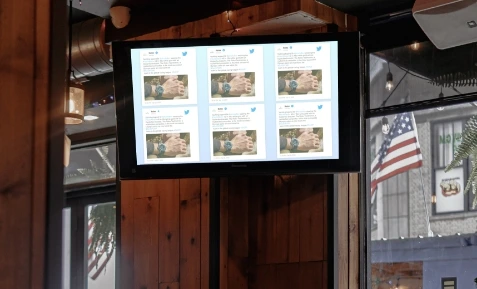 digital signage screen placed at office showing trending tweets using Pickcel's Twitter Plus app.