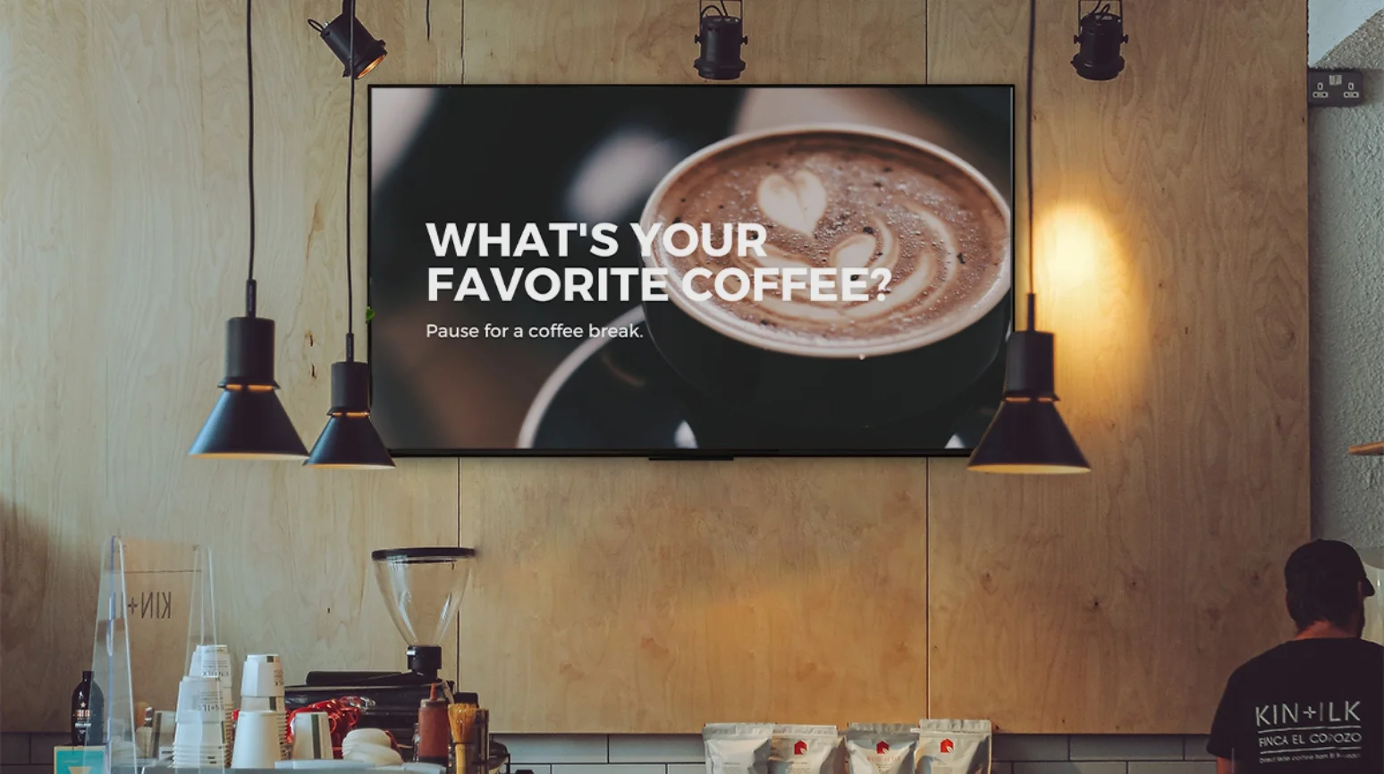 Cafeteria equipped with a large digital signage tv screen displaying promotional message about coffee