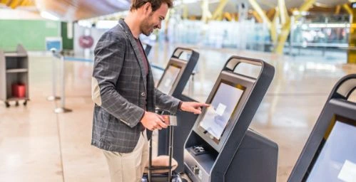 Customer interacting with touchscreen kiosk at Varanasi Airport which is powered by Pickcel's custom digital signage software