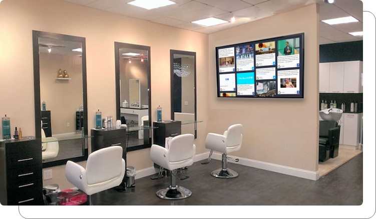 A digital signage screen showing client reviews in an office