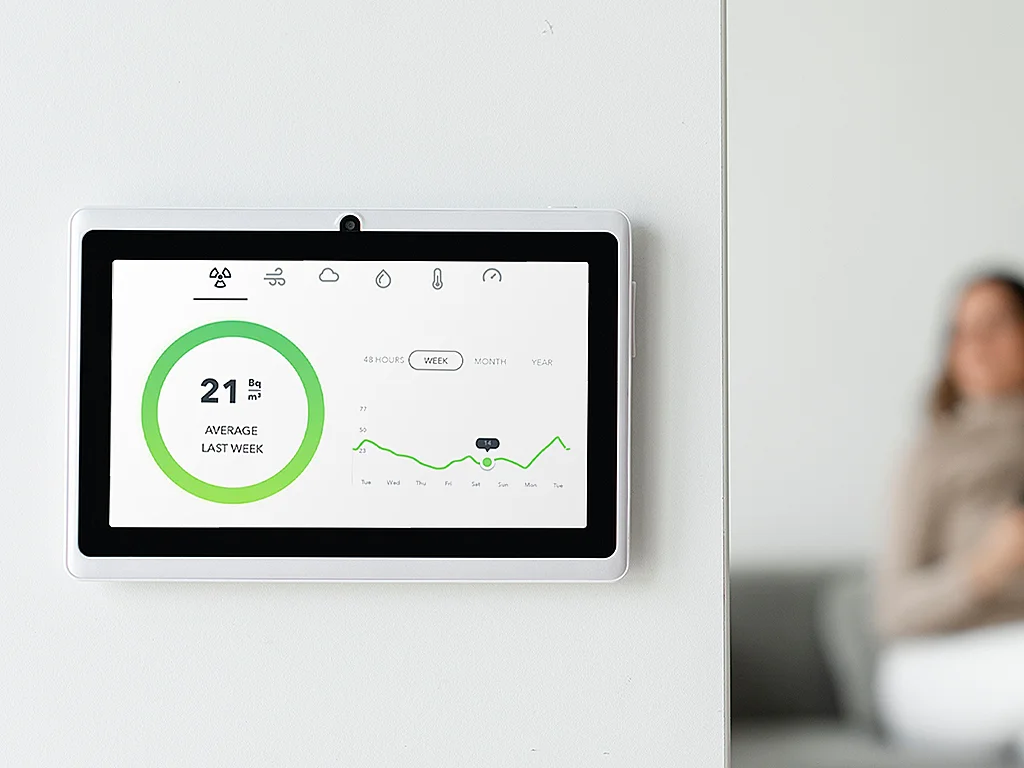 An indoor air quality monitoring device displays the average air quality results of last week with a graph