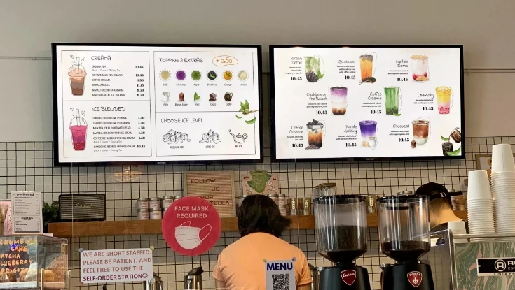 A cafe with digital menu boards showing the menu