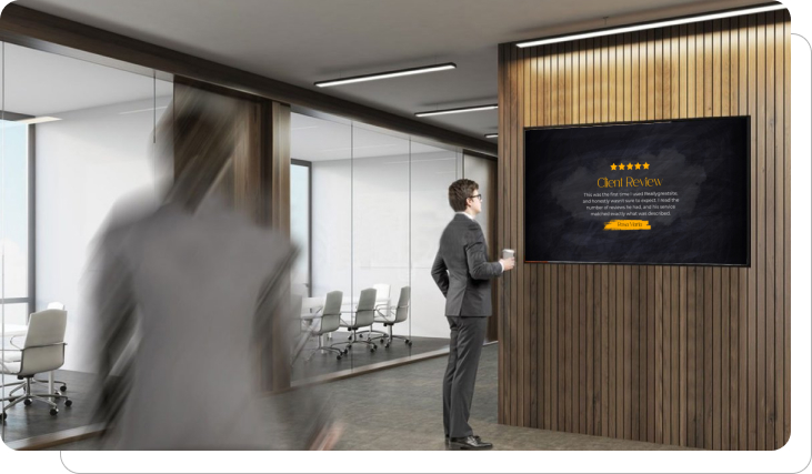A digital signage screen showing client reviews in an office