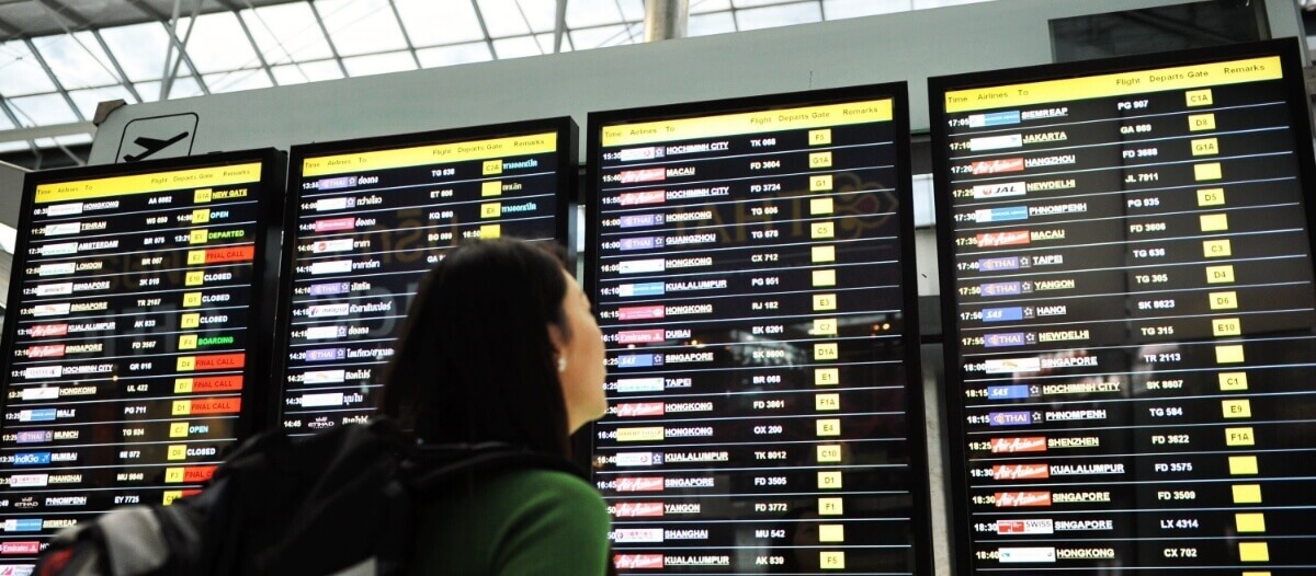 women viewing airport digital signage screen to check her flight timings