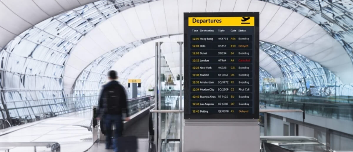 A digital signage screen showing departures at an airport