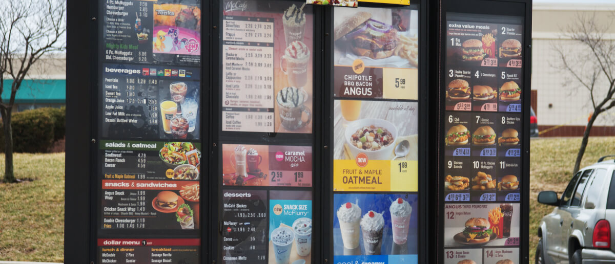 A drive-thru digital menu board showing discount offers