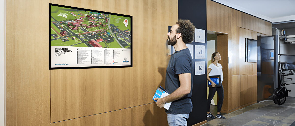 A campus wayfinding signage display being viewed by a student