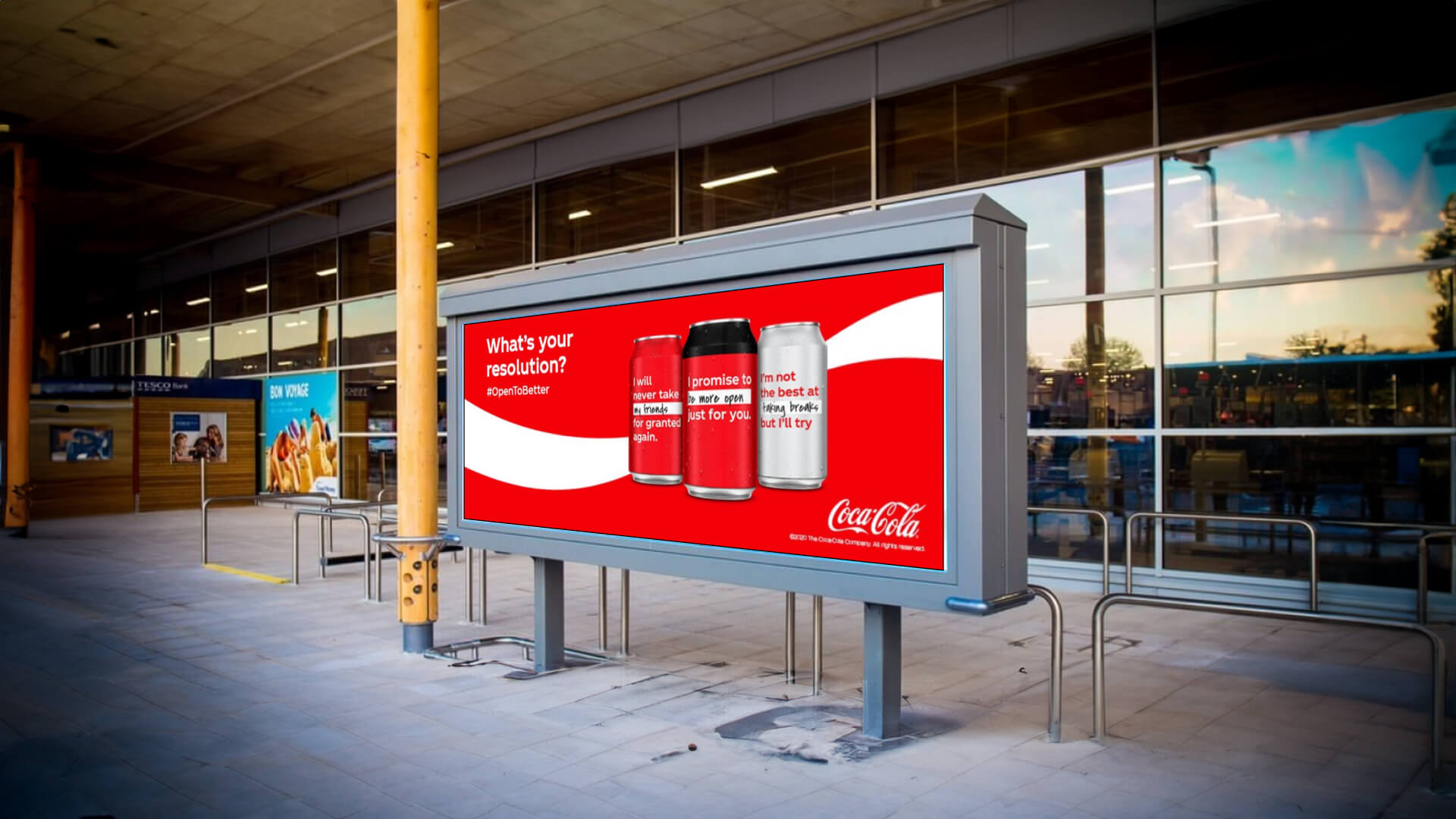 A digital footpath screen showing Coca Cola's brand slogans.