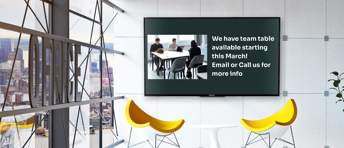 coworking space lobby equipped with digital signage screen displaying team table availability information