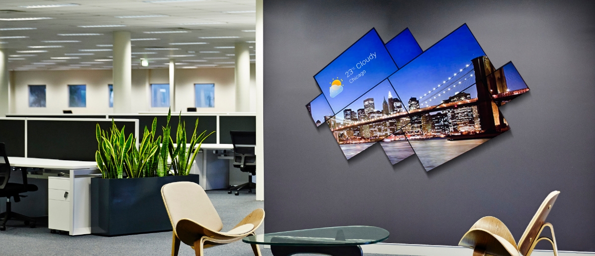 Mosaic video wall in an office lobby displaying night view of a city and weather updates