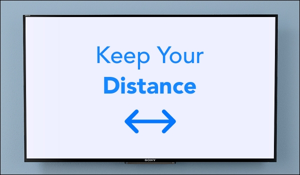 Digital sign board showing warning message 'keep your distance' in blue fonts