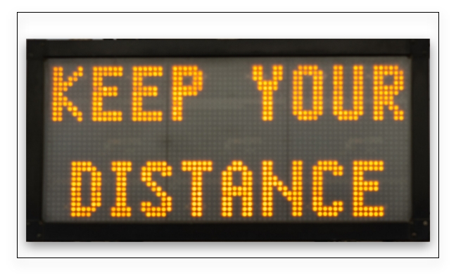 Electronic reader board showing a warning message 'keep your distance' in yellow LED light