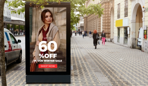 digital signage screen placed on the side of footpath displaying promotional offer from a famous winter wear brand