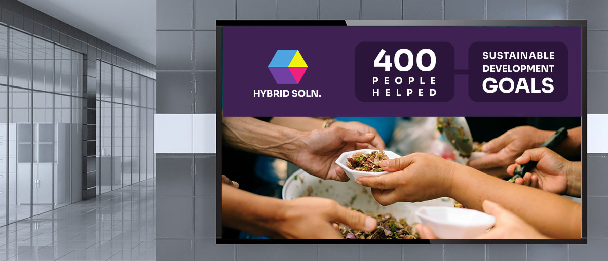 A digital signage screen shows images representing food charity program by a corporation