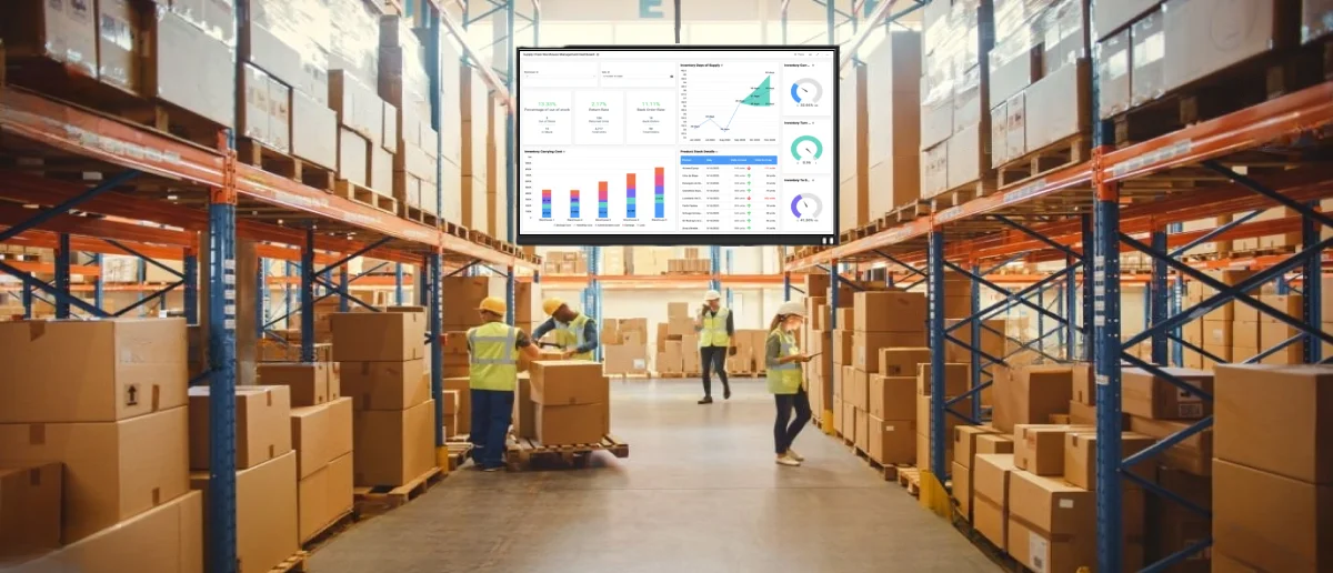 A digital signage screen at a JIT manufacturing plant shows a live dashboard to improve productivity.