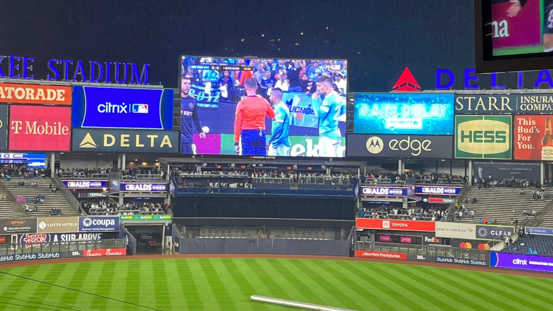 A football match is lives streaming on a stadium jumbo vision screen