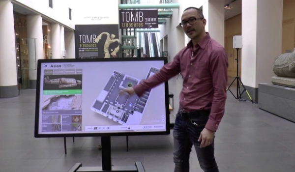 a man demonstrating wayfinding digital display board in a museum