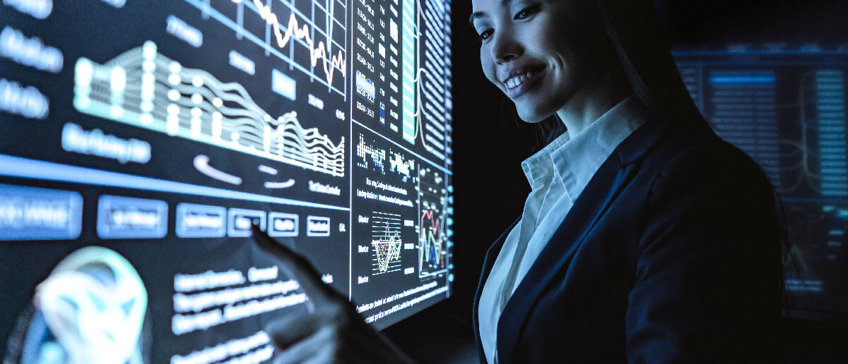 A woman interacts with a large digital signage screen