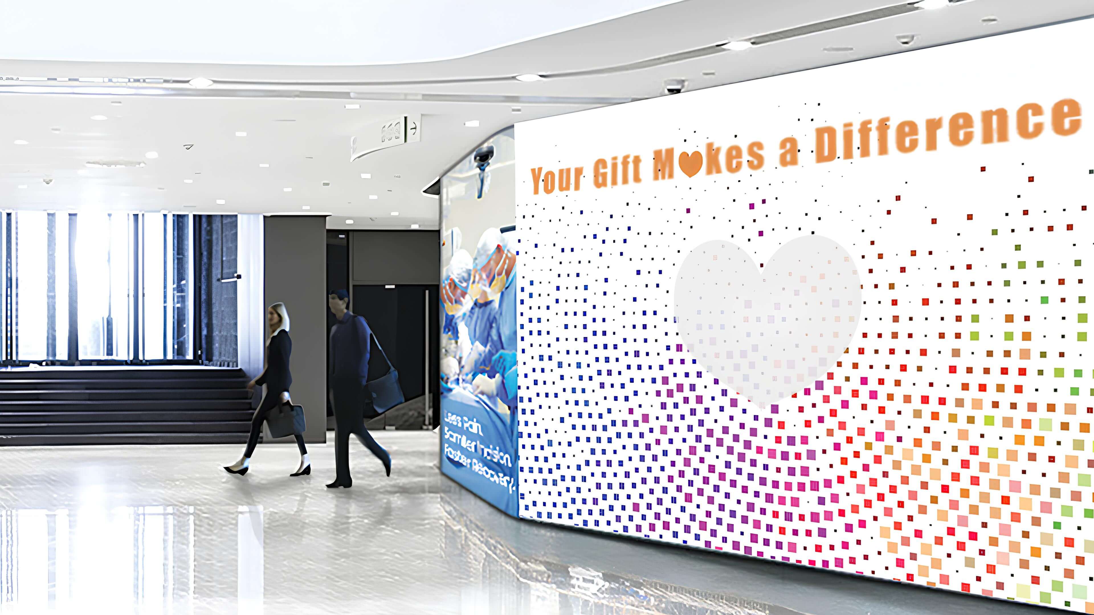 Digital signage wall reminding people to donate for a good cause.