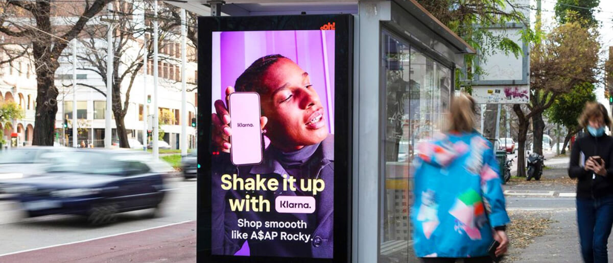 A dynamic digital signage display showing an ad outdoors.