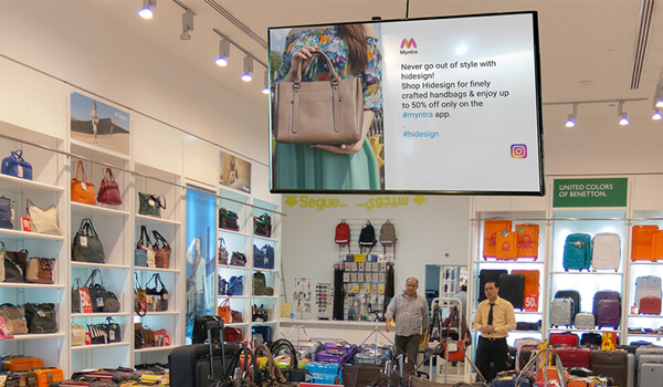 A retail store uses in-store digital signage at the central focal point of the store to attract audience attention.