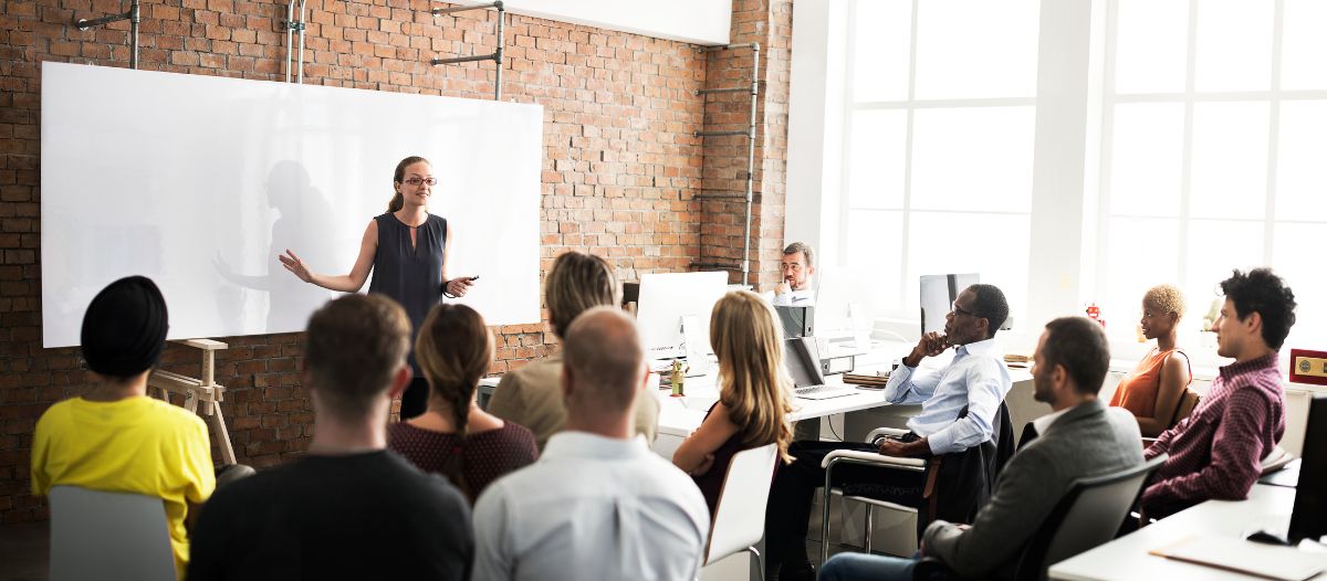 A young millennial employee gives a presentation to her team members in the workplace