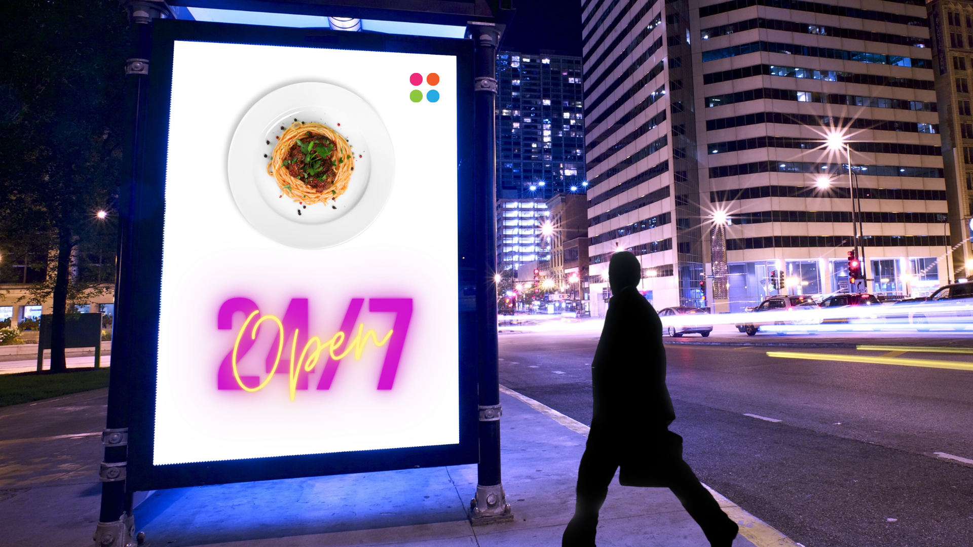 The dark silhouette of a man crossing an empty road appears to be staring at an outdoor digital signage display that shows the image of a nicely-plated spaghetti and the text ‘24/7 Open’. In the background, tall buildings and glowing street lights are partially visible.