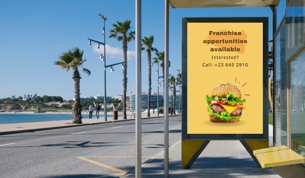 A bus stop digital signage shows an advertising that says Franchise opportunities are available.