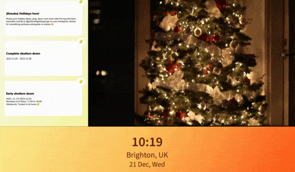 A digital bulletin board announces 'closed for holiday' notice alongside a video of a lit up Christmas tree