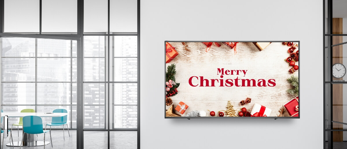 A wall-mounted lobby digital sign shows 'Merry Christmas' message