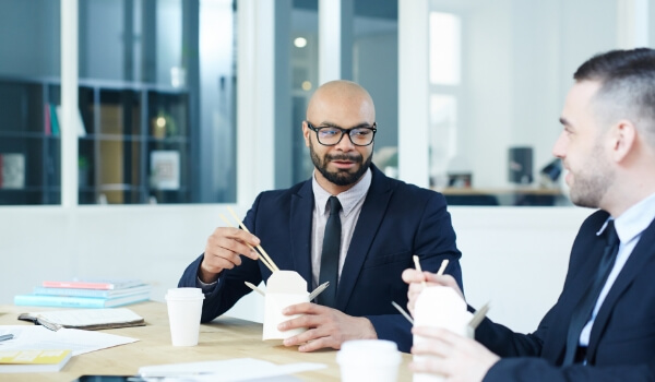 Two men in suits bond over a one-to-one employee-employer lunch