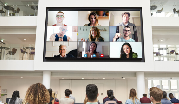 Video wall in an office foyer live streams a virtual Skype call. Via the screen, the global workforce communicates with the headquarter staff