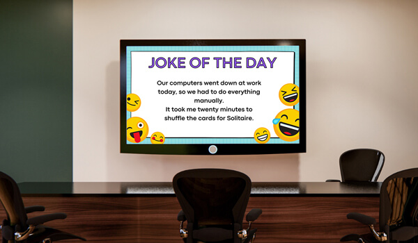 An office digital signage screen shows hilarious office jokes with laughing emoticons. The title reads: Joke of the Day