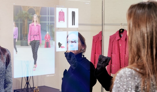 A woman interacts with a smart mirror in a clothing store trial room