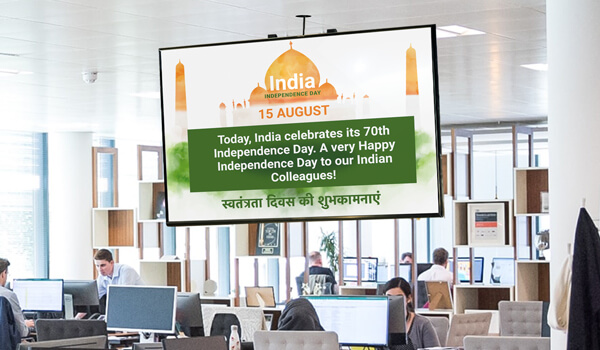 A digital screen in a global workplace wishes the expat Indian workers a happy Independence Day as part of inclusive workforce communication