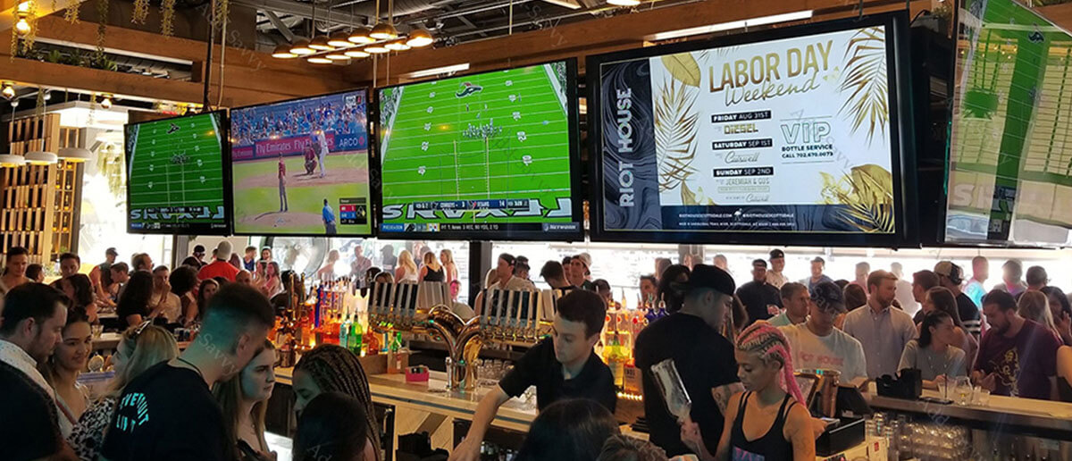 A series of digital signage screens showing offers, and sports at a pub