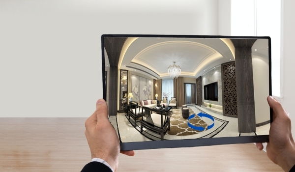 A man uses a tablet to check a real estate property via 360 degree virtual open house