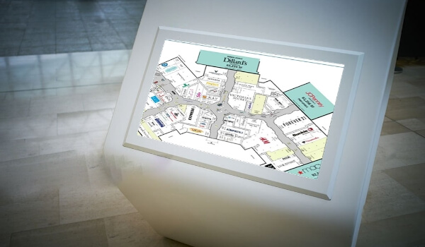 A white digital kiosk shows the layout of a real estate on the screen