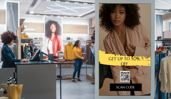 Digital standee inside a retail clothing store asks shoppers to scan a QR code to avail 50% discount on selected products