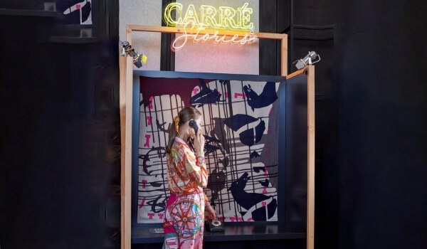 Hermes Carré Stories booth setup where a lady is listening to their scarves stories on a vintage dial phone.