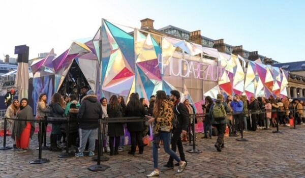 People waiting in a queue at Huda beauty retail pop-up to experience the retailtainment offered by the brand.