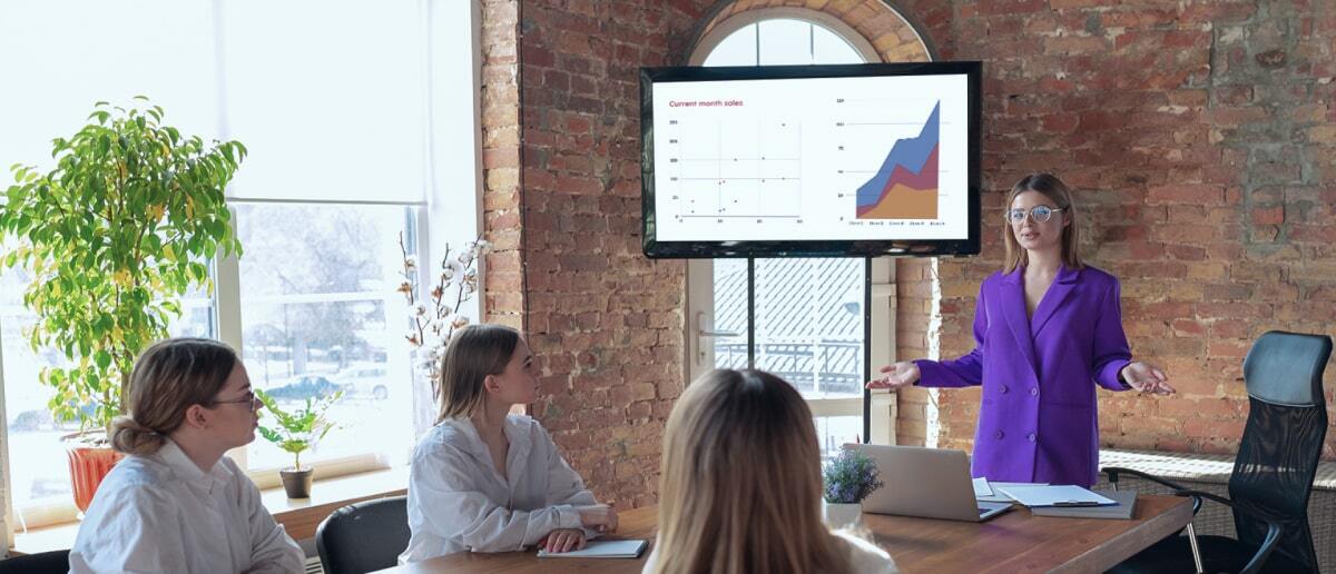 blog banner image showing employees discussing in a meeting room with digital signage placed on wall