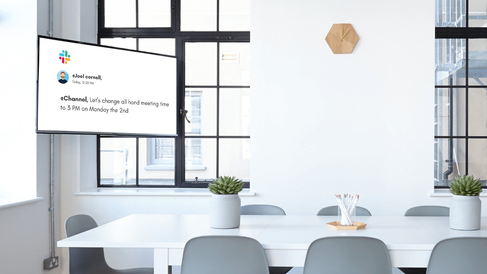 A corporate digital signage installed inside a conference room shows the messages on a Slack channel