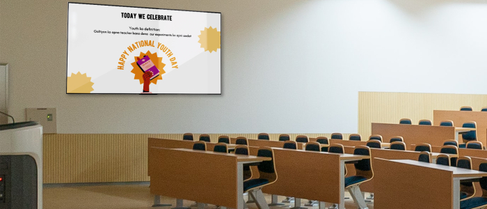 A large digital signage display installed inside a classroom shows an attractive poster on National Youth Day